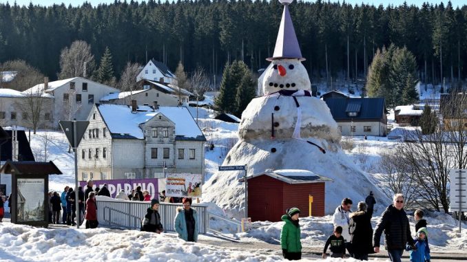 Der nach Angaben der Erbauer größte Schneemann Deutschlands zieht Schaulustige an. Foto: Jan Woitas