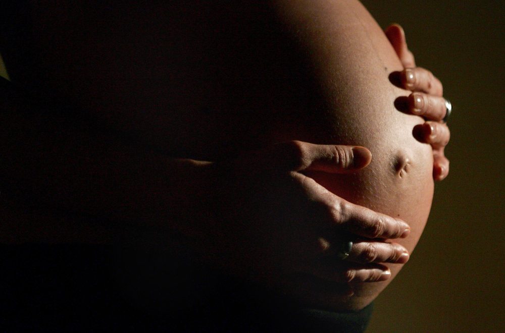 Eine hochschwangere Frau fasst sich mit beiden Händen an ihren Bauch. Foto: Felix Heyder/Archiv