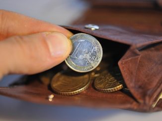 Eine Hand nimmt eine Euro-Münze aus einem Geldbeutel. Foto: Andreas Gebert/Archiv