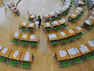 Saaldienerin verteilt im Sächsischen Landtag Unterlagen für die Abgeordneten. Foto: M.Hiekel/Archiv