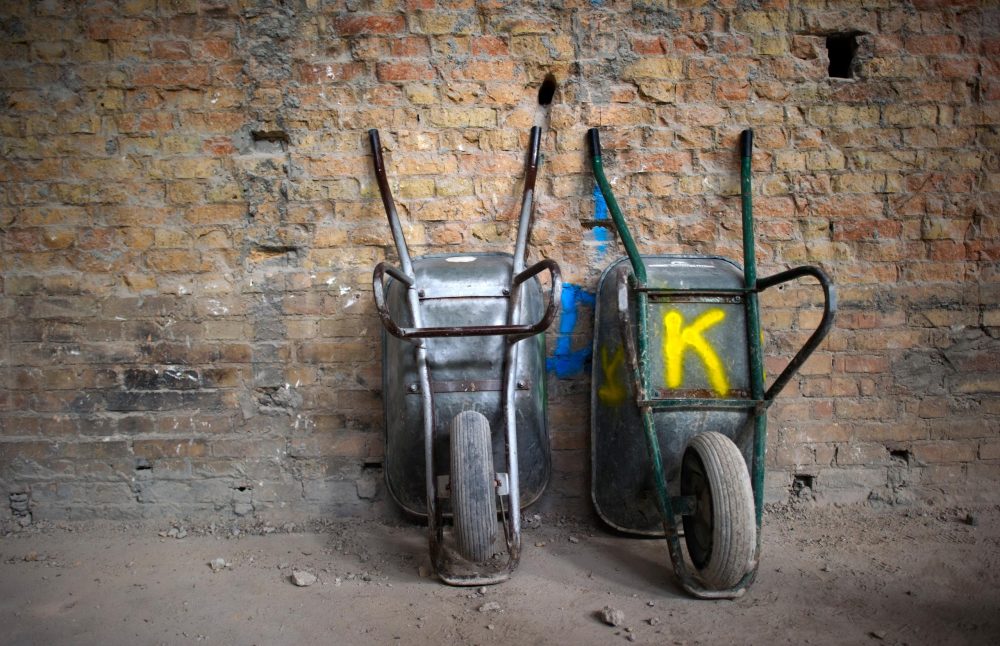 Zwei Schubkarren stehen an einer Wand. Foto: Arno Burgi/Archiv