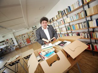 Jürgen Küfner (51), Direktor der Volkshochschule Dresden, zeigt einige der 13.000 geschenkten Bücher. Foto: Amac Garbe