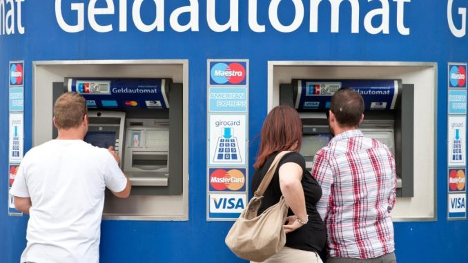 Kunden stehen an Bankautomaten. Foto: Tobias Kleinschmidt/Archiv