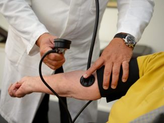 Ein Arzt misst einer Patientin den Blutdruck. Foto: Bernd Weissbrod/Archiv