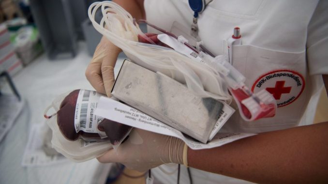 Eine Krankenschwester mit einer Blutspende in der Hand. Foto: Marijan Murat/Archiv