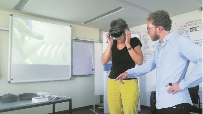 TÜV Rheinland Mitarbeiter Nils Brüggesch zeigt einer Berufskundeschulungsteilnehmerin die Funktion der Hololens. Fotos: PR