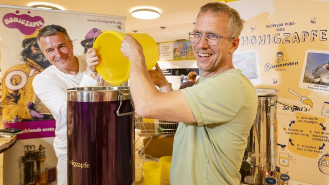 Honigzapfe bei Podemus in Coswig Imker Rico Heinzig (l.) und Podemus-Chef Bernhard Probst befüllen im Biomarkt Vorwerk Podemus in Coswig die Honigzapfe. Foto: Norbert Millauer