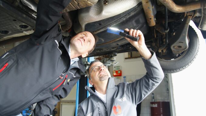Thomas Kubin vom ADAC und ELASKON-Werkstattmeister Jan Dünnebier prüfen den Unterboden eines Pkw. (Foto: Sabine Mutschke)
